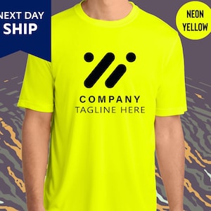 May include: Neon yellow t-shirt with a black logo and the text "COMPANY TAGLINE HERE." The shirt also has the text "NEXT DAY SHIP" and "NEON YELLOW" on the image.