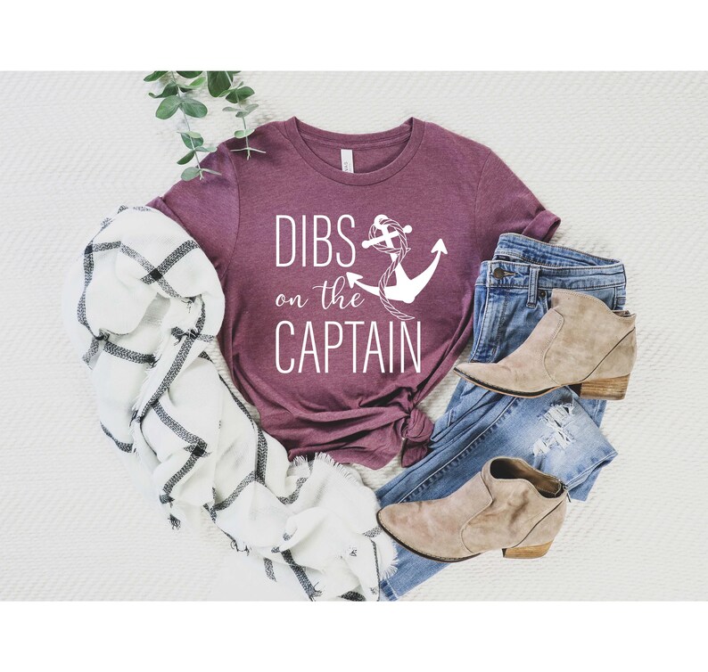 May include: A maroon t-shirt with the text "DIBS on the CAPTAIN" and a white anchor graphic.