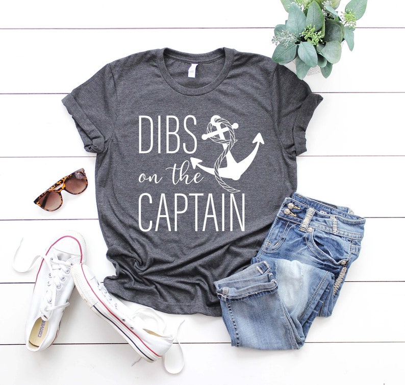 May include: A dark gray t-shirt with the text "DIBS on the CAPTAIN" and a white anchor graphic.