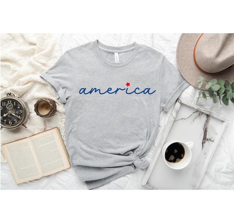 a t - shirt with the word america on it next to a cup of coffee