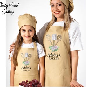 a woman and a girl wearing matching aprons