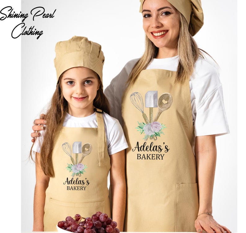 a woman and a girl wearing matching aprons