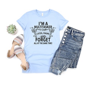 May include: A light blue t-shirt with a black graphic that says "I'm a Multitasker I can listen, ignore -and- forget all at the same time!"