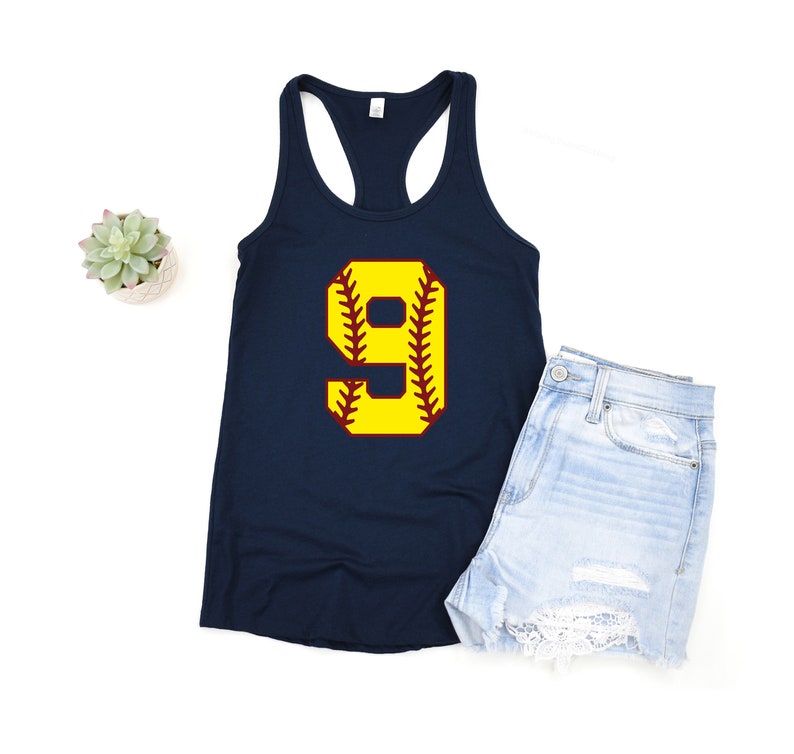 Puede incluir: Un top de tirantes azul marino con un n&uacute;mero 9 amarillo en la parte delantera. El n&uacute;mero 9 tiene la forma de una pelota de softball con costuras rojas.