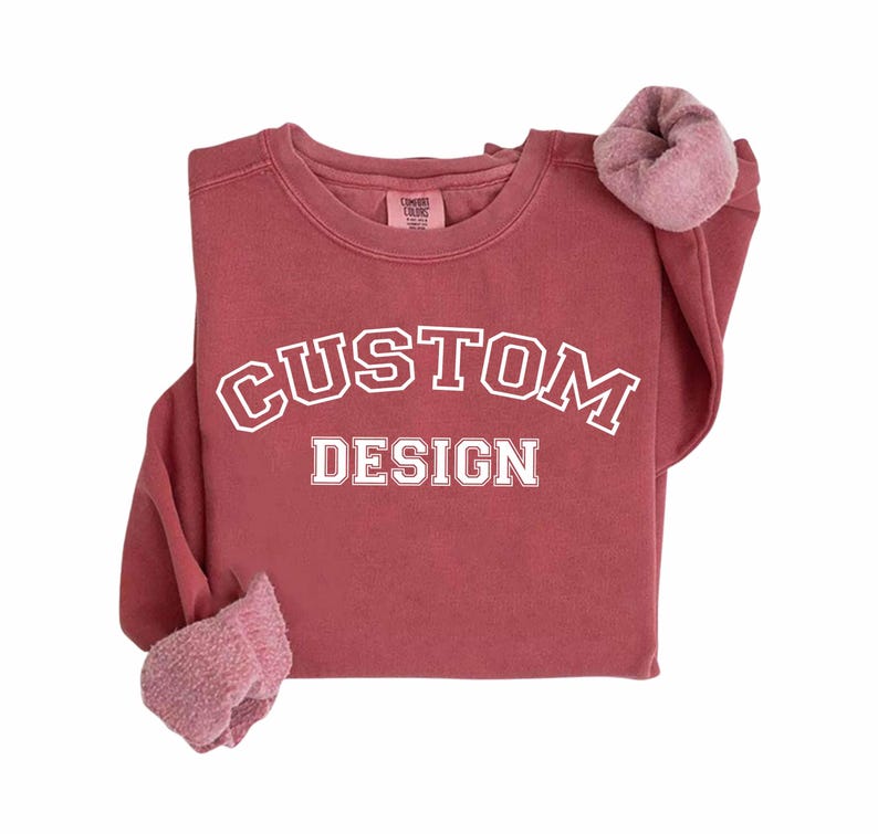 A red sweatshirt with the text "CUSTOM DESIGN" printed on it.