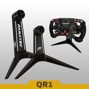 May include: Two black display stands with white Fanatec branding and a racing steering wheel mounted on a third stand. The stands feature a tripod-style base and a cylindrical top mount. The text QR1 is displayed in a yellow banner at the bottom.