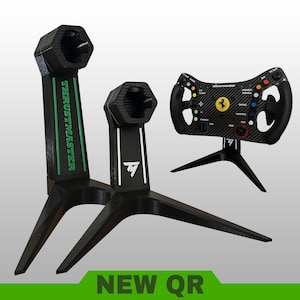 May include: Two black 3D-printed stands for gaming steering wheels, one tall with green Thrustmaster text and one shorter with a white TM logo. A black Ferrari-branded racing wheel is mounted on a separate stand, featuring colorful buttons.
