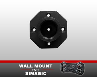 May include: A black octagonal wall mount for Simagic racing steering wheels. The mount features a central circular opening and four pre-drilled holes for installation. The text "WALL MOUNT FOR SIMAGIC" is printed below the mount next to a wheel.
