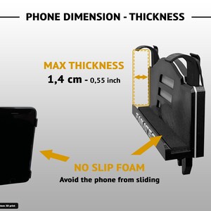 Op de afbeelding: Een zwarte 3D-geprinte telefoonhouder met het Fanatec-logo en antislipschuim. De afbeelding geeft een maximale telefoondikte van 1,4 cm aan en laat zien hoe de houder een smartphone stevig op zijn plek houdt.