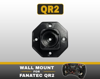 May include: A black octagonal wall mount for a Fanatec QR2 racing wheel base. The mount features four screw holes and a central circular opening. Text at the top reads QR2, and text at the bottom reads WALL MOUNT FOR FANATEC QR2.