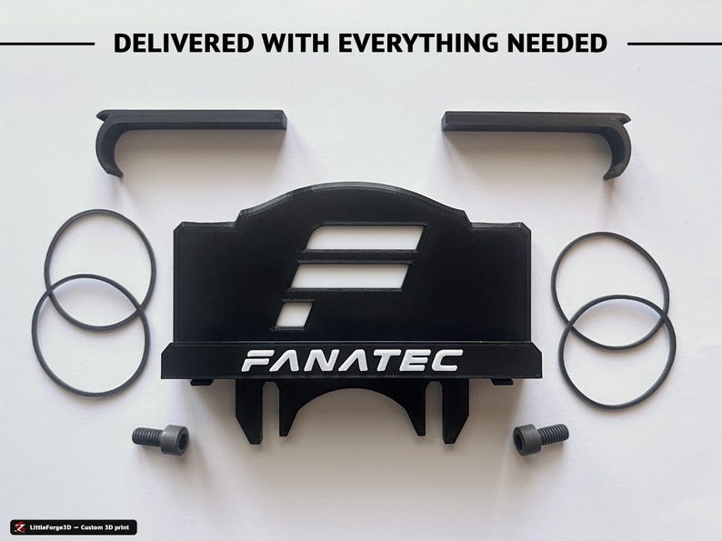 Op de afbeelding: Een zwarte 3D-geprinte Fanatec-accessoireset met een centrale montagebeugel met de tekst FANATEC, twee L-vormige clips, vier dunne zwarte rubberen O-ringen en twee grijze metalen bouten. De tekst DELIVERED WITH EVERYTHING NEEDED staat bovenaan.
