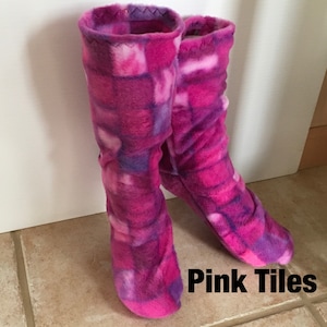 May include: A pair of pink and purple fleece slipper socks with a geometric pattern. The socks are called "Pink Tiles".