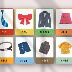 May include: A set of eight educational flashcards featuring illustrations of clothing items including a blue tie, red bow, gray blazer, pink skirt, brown belt, blue shorts, gray vest, and a yellow floral shirt with the text labels below each.