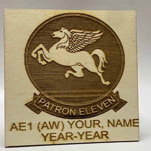 May include: A wooden plaque with a laser-engraved image of a winged horse, a circle around it, and the text "PATRON ELEVEN". Below the image is the text "AE1 (AW) YOUR, NAME YEAR-YEAR".