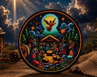 May include: A circular decorative plaque featuring a vibrant, detailed nativity scene illustration. The artwork depicts a central manger, figures of people, animals, and a flying angel under a starry night sky with clouds and evergreen trees.