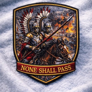 May include: Embroidered patch depicting two knights in armour on horseback, holding a spear, with a battle scene in the background. The shield-shaped patch has the text "NONE SHALL PASS" on a red banner.