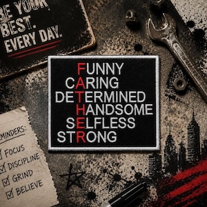 May include: A rectangular black embroidered patch featuring the white text FATHER arranged vertically with the letters F, A, T, H, E, R highlighted in red. The words FUNNY, CARING, DETERMINED, HANDSOME, SELFLESS, and STRONG are stitched in white.