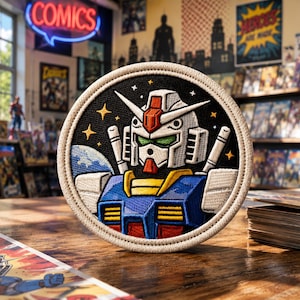 May include: Embroidered patch featuring a robot character with a white head, red and orange accents, and a blue and yellow body. The patch is round with a black background and white border. The word "COMICS" is in a neon sign in the background.