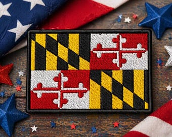 Puede incluir: Parche bordado con la bandera del estado de Maryland, con borde negro. El diseño de la bandera incluye un patrón negro y amarillo, y cruces rojas y blancas. Estrellas patrióticas y una bandera en el fondo.