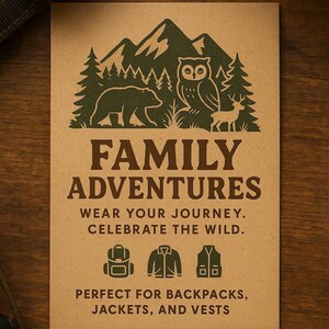 May include: A rectangular tan card featuring dark green illustrations of mountains, pine trees, a bear, an owl, and a deer. The text reads: FAMILY ADVENTURES, WEAR YOUR JOURNEY. CELEBRATE THE WILD. Icons of a backpack, jacket, and vest are displayed above the text: PERFECT FOR BACKPACKS, JACKETS, AND VESTS.