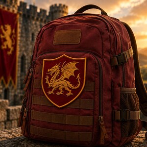 K&ouml;nnte beinhalten: Ein dunkelroter Rucksack mit einem auff&auml;lligen schildf&ouml;rmigen Aufn&auml;her, der einen goldenen Drachen zeigt. Der Rucksack verf&uuml;gt &uuml;ber mehrere horizontale Gurtb&auml;nder, seitliche Netztaschen, verstellbare Schnallen und ein rechteckiges Feld oben.