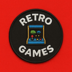 May include: Embroidered patch with the words "RETRO GAMES" in white, surrounding a blue and yellow arcade game machine. The arcade game machine has a joystick and two buttons. The patch is on a black background and a red surface.