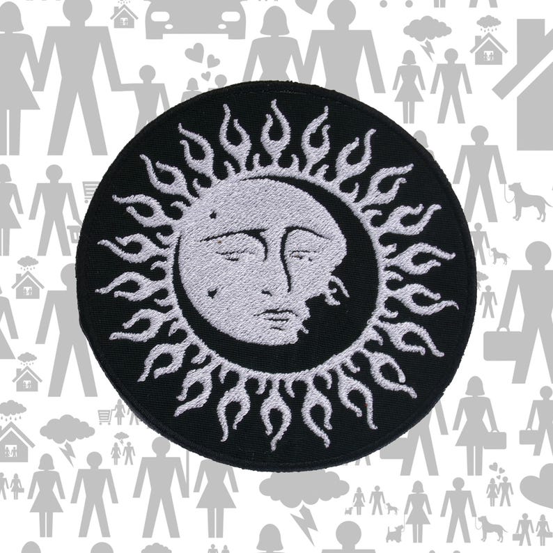 May include: A circular embroidered patch featuring a white sun face with a human-like expression, surrounded by stylised white flame rays against a solid black background. The design is centred and circular with a stitched border edge.