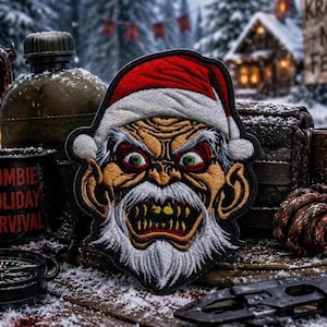 May include: An embroidered patch featuring a stylized, menacing Santa Claus face with a red and white hat, bright green eyes, and sharp yellow teeth. The design includes a white beard and mustache, with a black border outlining the entire shape.