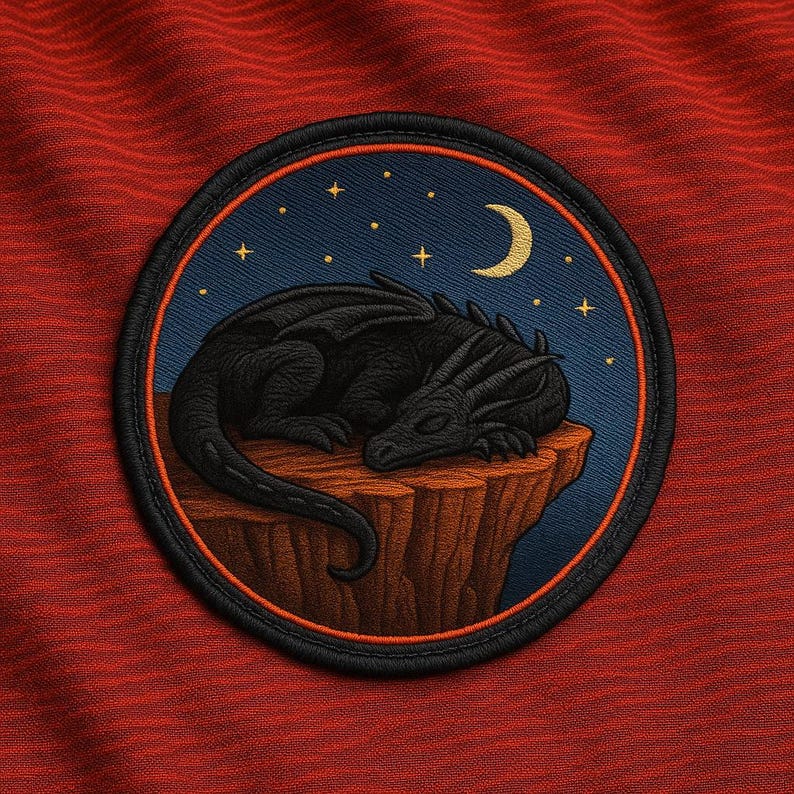 May include: Embroidered patch featuring a black dragon sleeping on a cliff under a starry night sky with a crescent moon. The patch has a black border and is set against a red textured background.