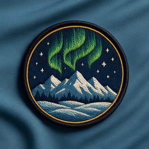 May include: A circular embroidered patch featuring a night scene with snow-capped mountains, a dark blue sky filled with white stars, and vibrant green aurora borealis lights above. The patch has a thick black border with a thin gold inner ring.