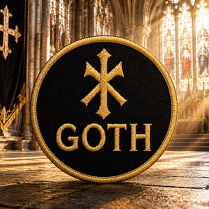 May include: A circular black embroidered patch with a gold border. The patch features a gold Chi Rho symbol centered above the word GOTH, which is also stitched in gold thread. The design is clean, with bold lettering and a distinct religious icon.