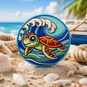 May include: Round embroidered patch featuring a cartoon sea turtle swimming in front of a wave. The turtle has a yellow head, orange shell, and green body. The patch is surrounded by a blue border and set on a sandy beach.
