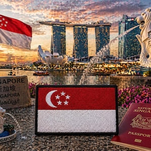 May include: A rectangular patch featuring the red and white Singaporean flag with a white crescent moon and five stars. Beside it sits a small Merlion figurine and a red Republic of Singapore passport, all set against a backdrop of the Singapore skyline.