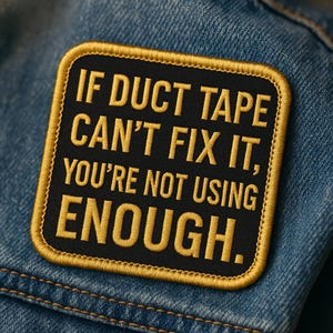 以下が含まれることがあります： デニムジャケットに縫い付けられた、金色の文字とトリムが付いた黒色の刺繍パッチ。テキストは「ダクトテープで直せないなら、足りない」と書かれています。