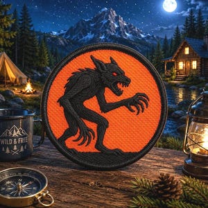 May include: A circular embroidered patch featuring a black werewolf silhouette with glowing red eyes centered on a vibrant orange background, finished with a black stitched border, presented as a standalone decorative item.