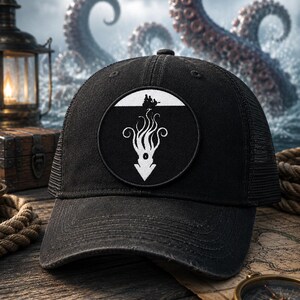 May include: A black baseball cap featuring a circular patch on the front. The patch displays a white graphic of a squid silhouette beneath a small boat with figures, set against a black background. The cap has a structured crown and mesh back.