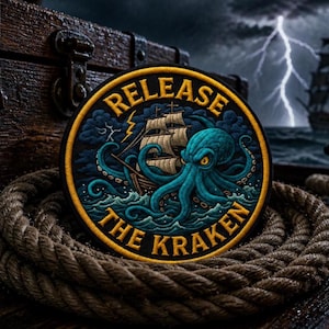 May include: A circular embroidered patch featuring a teal octopus attacking a sailing ship amidst stormy waves. The text "RELEASE THE KRAKEN" is stitched in yellow along the top and bottom borders of the patch, which is set against a dark background.