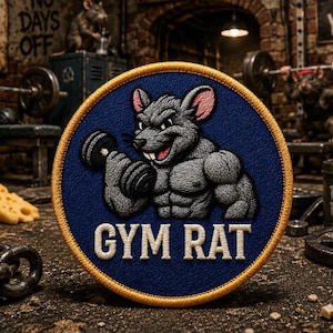 May include: A circular embroidered patch featuring a muscular gray rat with pink-lined ears lifting a black dumbbell. The design is set against a dark blue background with a yellow border. The text GYM RAT is stitched in white at the bottom.