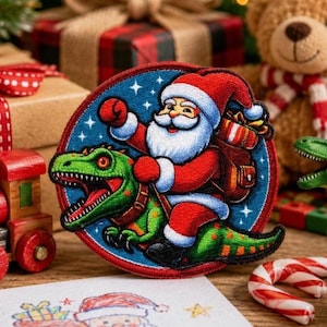 May include: A circular embroidered patch featuring a cartoon Santa Claus with a white beard and red suit riding a green Tyrannosaurus Rex. Santa carries a brown sack filled with gifts against a dark blue background with white stars.