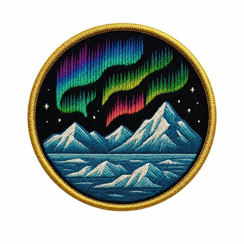 May include: A circular embroidered patch featuring a night sky with vibrant green, purple, and pink aurora borealis above snow-capped blue mountains and a dark blue sea. The design is framed by a thick, golden-yellow stitched border.