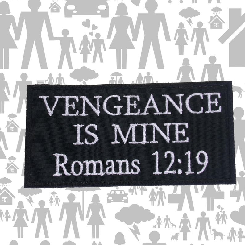 Op de afbeelding: Zwart rechthoekig embleem met witte geborduurde tekst: "VENGEANCE IS MINE Romeinen 12:19". Het embleem staat tegen een witte achtergrond met grijze silhouetten van mensen, huizen en auto's.
