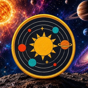 Könnte beinhalten: Ein kreisförmiger, bestickter Aufnäher mit einer zentralen gelben Sonne, die von konzentrischen weißen Umlaufbahnen umgeben ist. Das Design zeigt kleine rote und blaue Planeten, einen orangefarbenen Planeten mit Ringen und gelbe Sterne auf schwarzem Grund.