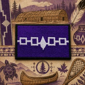 May include: A rectangular embroidered patch featuring a deep purple background with a central white design consisting of four squares connected by a horizontal line and a central arrowhead shape, all bordered by a thick black stitched edge.