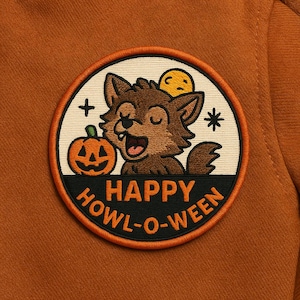 Peut inclure: Un écusson circulaire avec un loup brun, une citrouille d'Halloween et le texte "HAPPY HOWL-O-WEEN". L'écusson a un fond blanc avec des accents orange et noirs. Le loup sourit les yeux fermés. L'écusson est sur un fond orange.