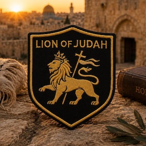 Peut inclure: Un écusson noir en forme de bouclier avec une broderie dorée représentant un lion portant une couronne et tenant un bâton surmonté d'une croix. Le texte LION OF JUDAH est brodé en or en haut de l'écusson, bordé d'un liseré doré.