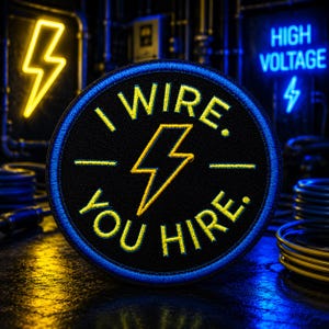 May include: A round black patch with a blue border and yellow embroidered text that reads "I WIRE. YOU HIRE." A yellow lightning bolt is in the center. The background features neon lightning bolt signs and electrical wiring.