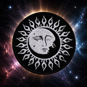 May include: A circular embroidered patch featuring a white sun face with closed eyes and a crescent moon silhouette integrated into the design. The sun is surrounded by white flame-like rays against a solid black background with a stitched border.