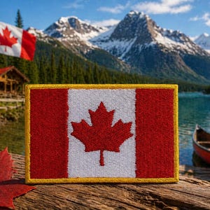 May include: A rectangular patch of the Canadian flag, with a red maple leaf on a white background, framed by red bars. The patch is set against a scenic backdrop of a lake, mountains, and a Canadian flag.