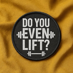 Puede incluir: Un parche bordado negro y circular con el texto "DO YOU EVEN LIFT?" en blanco. El parche presenta ilustraciones de pesas rusas encima y debajo del texto, sobre un fondo amarillo.