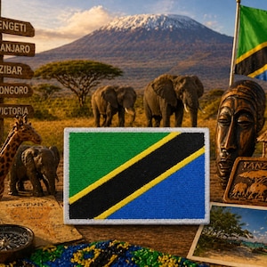 May include: A patch featuring the Tanzanian flag with green, black, yellow, and blue colors. The image includes a wooden signpost with African destinations, a giraffe figurine, elephants, and a mountain in the background. A wooden mask and a small wooden carving of elephants are also visible.